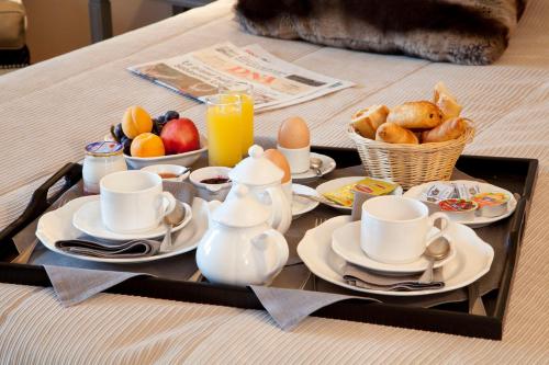 a tray of breakfast foods and coffee on a table at Logis Hotel Le Parc & Spa in Saint-Hippolyte