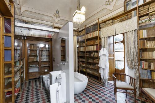 a bathroom with a library with a tub and a toilet at Edel Modica in Modica