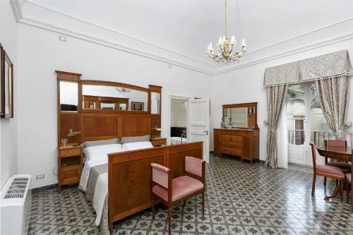 a bedroom with a bed and a desk and a chair at Edel Modica in Modica