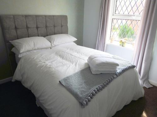 een slaapkamer met een wit bed en een raam bij Exquisite Apartment Hessle in Hessle