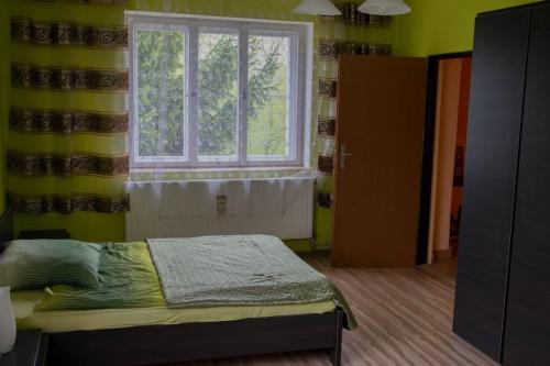 a bedroom with a bed in front of a window at Gospodarstwo u Krakusa in Doboszowice