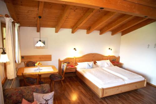 a bedroom with a bed and a desk and a table at Ferienwohnungen Mueller in Oberstdorf
