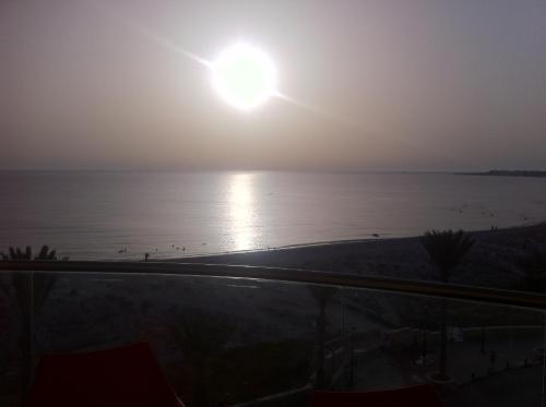 a view of the ocean at sunset from a balcony at Immeuble l'Espadon in Mahdia