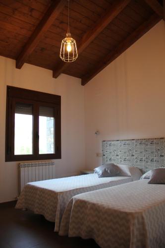 a bedroom with two beds and a light fixture at Casa sierra ferrera in Samper