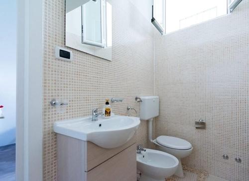 a white bathroom with a sink and a toilet at Casa vacanza Simone in Andria