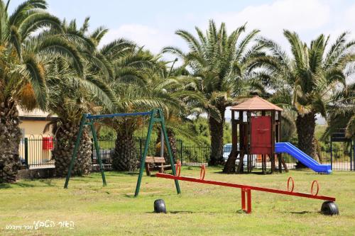 a playground with a slide and a swing set at Dor village in Dor