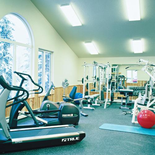 a gym with treadmills and machines in a room at Kandahar Lodge at Whitefish Mountain Resort in Whitefish