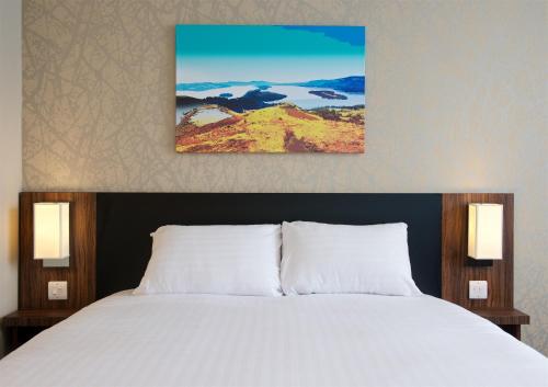 a bedroom with a large bed with white sheets at Chain Runner, Livingston by Marston's Inns in Livingston
