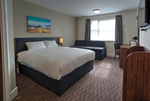 um quarto de hotel com uma cama e um sofá em Chain Runner, Livingston by Marston's Inns em Livingston