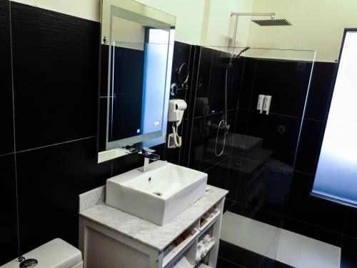 a bathroom with a sink and a mirror and a toilet at Bei Boutique Hotel in Muar
