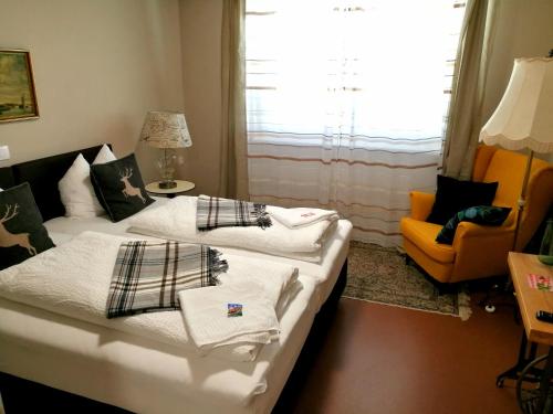una sala de estar con 2 camas y una silla naranja en Cafe-Restaurant LEO en Kalsdorf bei Graz