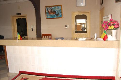 a counter in a room with flowers and flags at Hotel Safari COTONOU in Cotonou