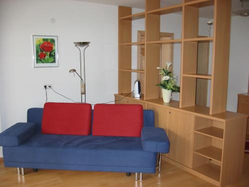 a blue couch with two red pillows in a living room at Appartements Sonnwend in Gerlos