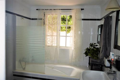 バルセキージョにあるCottage Gran Canaria En Reformasの白いバスルーム(バスタブ付)、窓が備わります。