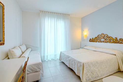 a white bedroom with a bed and a couch at Hotel Albatros 3 Stelle Superior in Lido di Jesolo