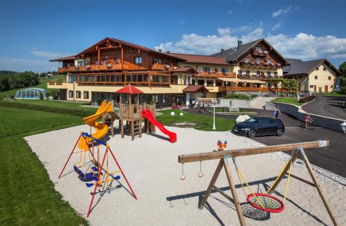 a playground in front of a large building at Panorama Hotel Gasthof Leidingerhof in Mondsee