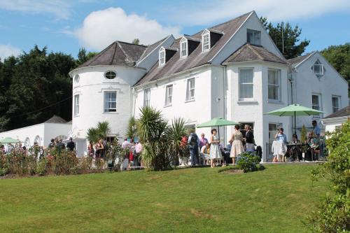 a group of people standing outside of a large white house at Innishannon House Hotel in Inishannon