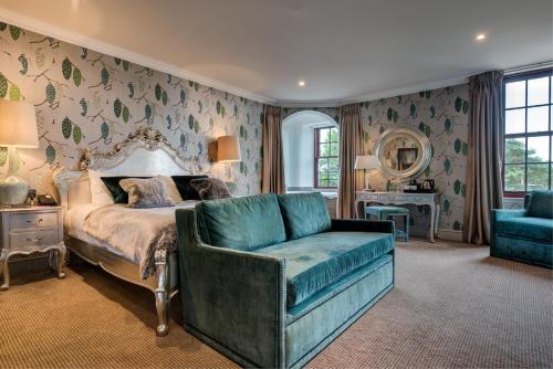 a bedroom with a bed and a couch and a chair at Gleddoch Golf & Spa Resort in Langbank