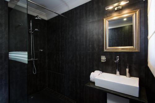 a bathroom with a sink and a shower and a mirror at The Citizen in Antananarivo