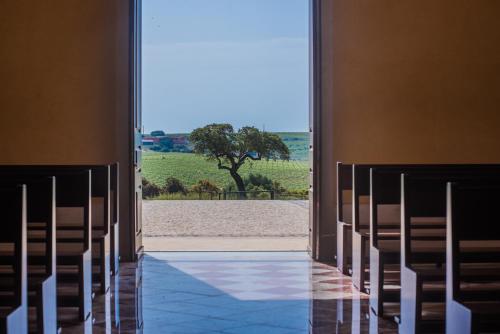 an aisle of a church with chairs and a tree at Vila Gale Alentejo Vineyard - Clube de Campo in Albernoa