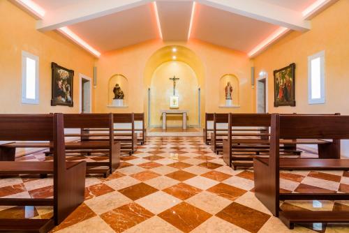 a church with wooden pews and a cross on the wall at Vila Gale Alentejo Vineyard - Clube de Campo in Albernoa