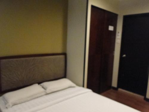 a bed with two white pillows in a room at Hotel Sadong88 in Kota Kinabalu