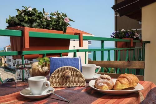 een tafel met 2 kopjes koffie en croissants op een balkon bij Le mansardine in Vasto