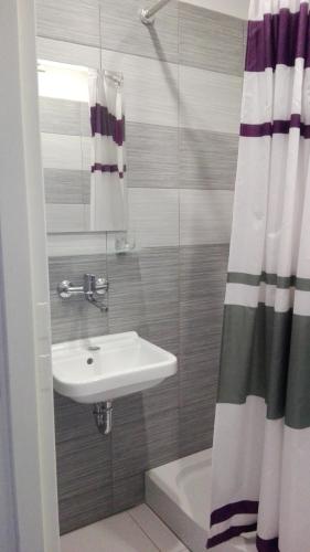 a bathroom with a sink and a shower curtain at HOTEL ODR in Sulechów