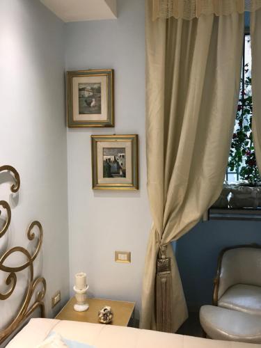 サレルノにあるChèz Lumièreのベッドルーム1室(ベッド1台付)、窓(カーテン付)