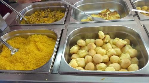 un buffet pieno di diversi tipi di cibo in vassoi di Hotel Brisa do Aracati a Aracati
