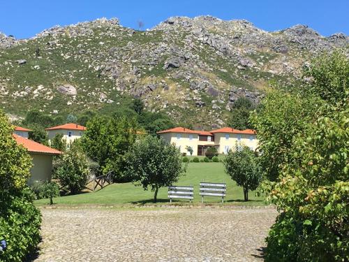 un parc avec un banc en face d'une montagne dans l'établissement Quinta das Mineirinhas, à Vila Nova de Cerveira