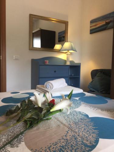 a bedroom with a blue bed with a bouquet of flowers on it at Il posto ideale - with private parking in Rome