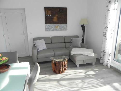 sala de estar con sofá y mesa en Villa Bettina - Ferienwohnung 11 en Heringsdorf