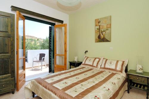 a bedroom with a bed and a sliding glass door at Elea Houses in Mithymna