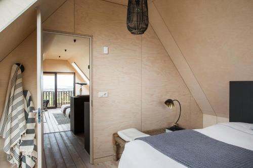 a attic bedroom with a bed and a staircase at Barn house by the sea in Stokkseyri