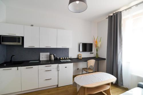 Una cocina con gabinetes blancos y una mesa y una silla. en Old Town Szczecin, en Szczecin