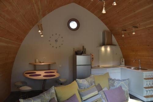 sala de estar con sofá y cocina en Cabanons Jour & Nuit, en Mazan