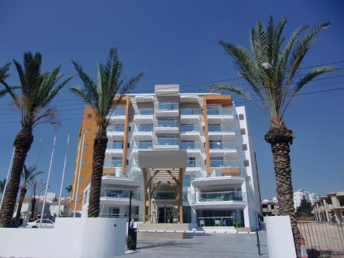 um hotel com palmeiras em frente em Captain Pier Hotel em Protaras