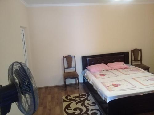 a bedroom with a bed and a fan at Guest House Gikacha in Tbilisi City