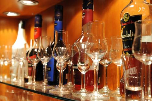 a bunch of wine bottles and wine glasses on a counter at Gizella Hotel and Restaurant in Veszprém