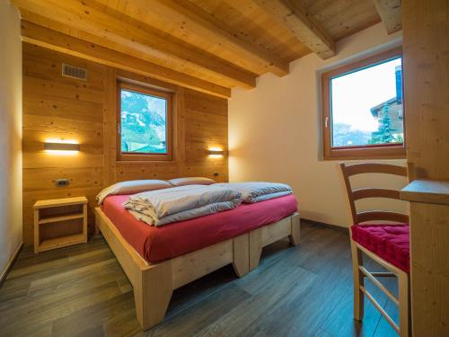 リヴィーニョにあるappartamento arcadiaの木造キャビン内のベッド1台が備わるベッドルーム1室を利用します。