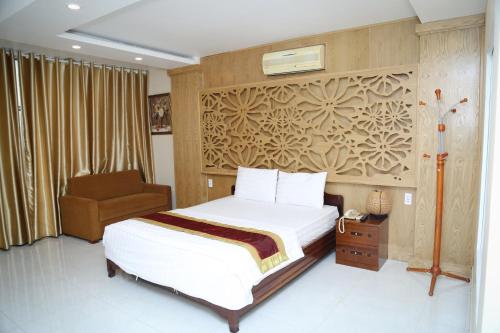 a hotel room with a bed and a chair at Phu Qui Hotel in Soc Trang