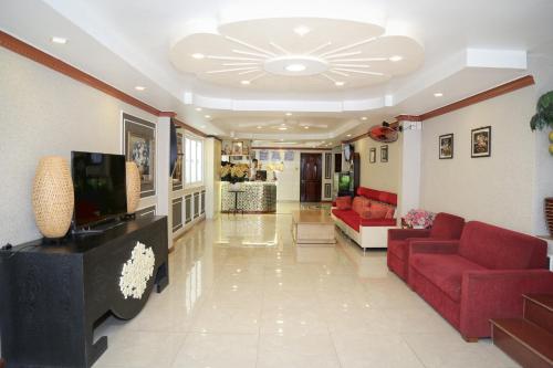 sala de estar con sofá rojo y TV en Phu Qui Hotel, en Soc Trang