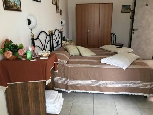 ein Schlafzimmer mit einem großen Bett und einem Tisch in der Unterkunft Hotel Ebe in San Piero a Sieve