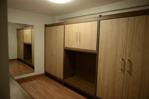 an empty room with wooden cabinets in a room at Hotel Vilhar in Ivaiporã
