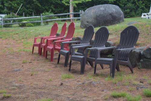 a row of chairs sitting in the grass at The Long View Lodge in Long Lake