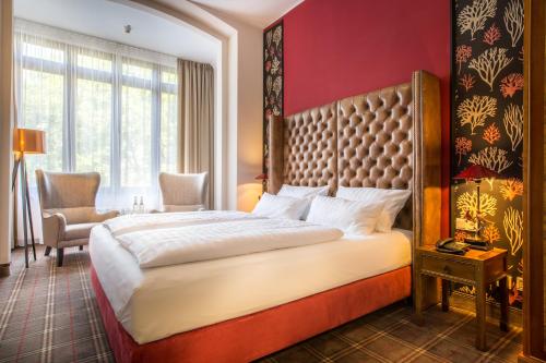 a bedroom with a large bed and a red wall at The Ascot Hotel in Cologne