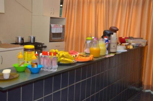 a counter in a kitchen with food and drinks on it at Hotel Alvorada I in Sete Lagoas