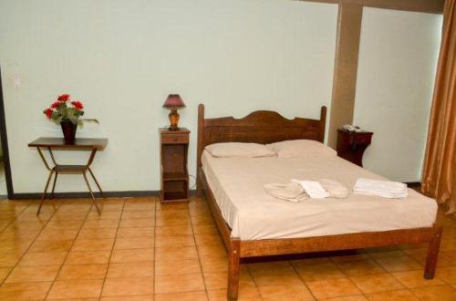 a bedroom with a bed with two towels on it at Hotel Alvorada I in Sete Lagoas