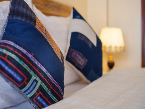 a bed with blue pillows on top of it at Sapa Centre Hotel in Sa Pa